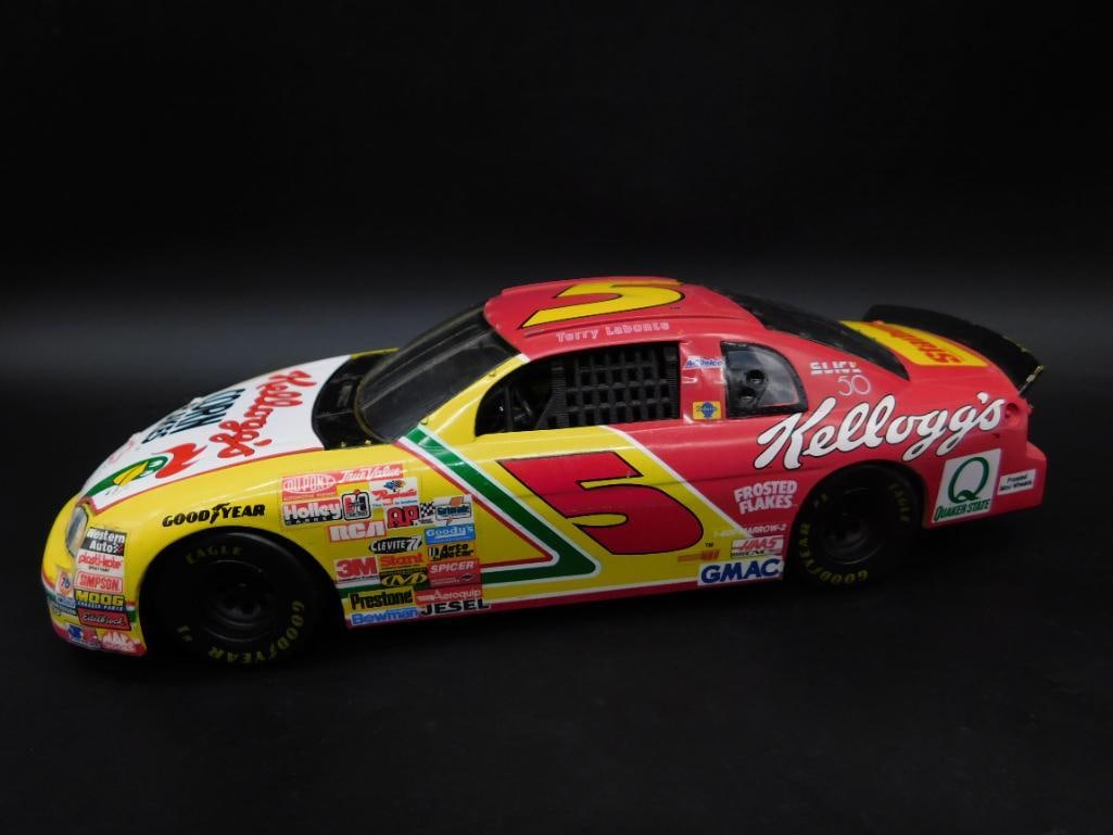 NASCAR Kellogg?s #5 Die-Cast Car Model with Details: NASCAR die-cast model car featuring Kellogg's #5 design. Includes accurate exterior graphics and sponsor logos. Hood and undercarriage details are present, showcasing the engine components and structu
