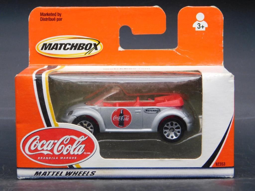 Matchbox Coca-Cola Branded Toy Car in Original Packaging: This is a Matchbox toy car branded with Coca-Cola, featuring Mattel Wheels and Fiat 500 design. It comes sealed in its original packaging, ensuring the item's condition and collectible appeal. Packagi