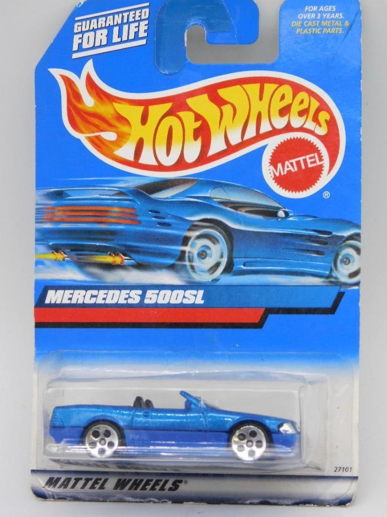 Hot Wheels Mercedes 500SL in Original Packaging: Hot Wheels Mercedes 500SL die-cast toy car, still sealed in its original packaging. Features a blue car model with detailed design and silver rims. Packaging is marked with 'Guaranteed for Life' and t