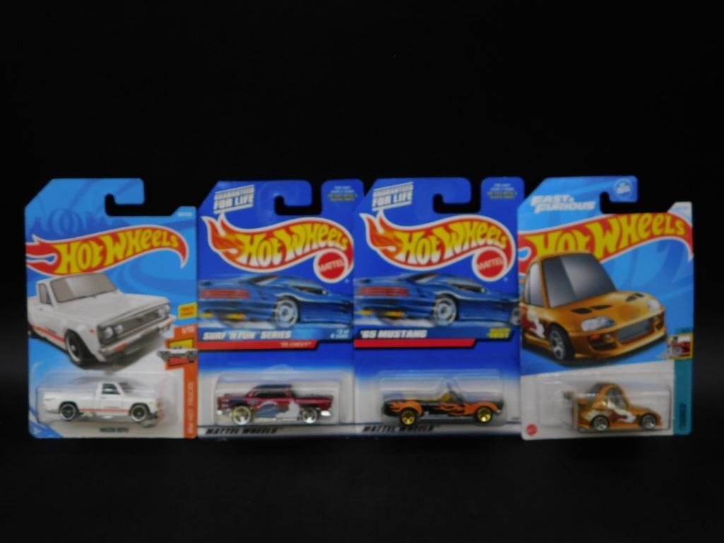 Lot of 4 Sealed Hot Wheels Cars in Original Packaging: This lot includes four Hot Wheels cars, each sealed in its original packaging. The selection features various models, including a blue '65 Mustang, a white truck, a gold 84 Toyota Supra, and a Hot Whe