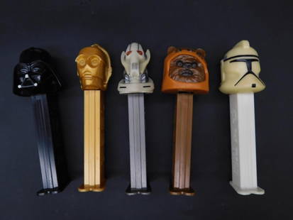 Set of 5 Star Wars Pez Dispensers with Various Characters: This lot features a set of 5 Pez dispensers inspired by Star Wars characters. The designs include popular figures such as Darth Vader, C-3PO, an Ewok, and others. Each dispenser is stamped with 'U.S.
