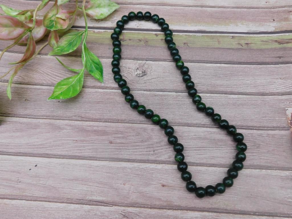 Green Beaded Necklace with Round Natural Stone Beads: This green beaded necklace features round natural stone beads strung together for a classic design. The stones exhibit a marbled appearance with varying shades of green. The necklace appears to be unm