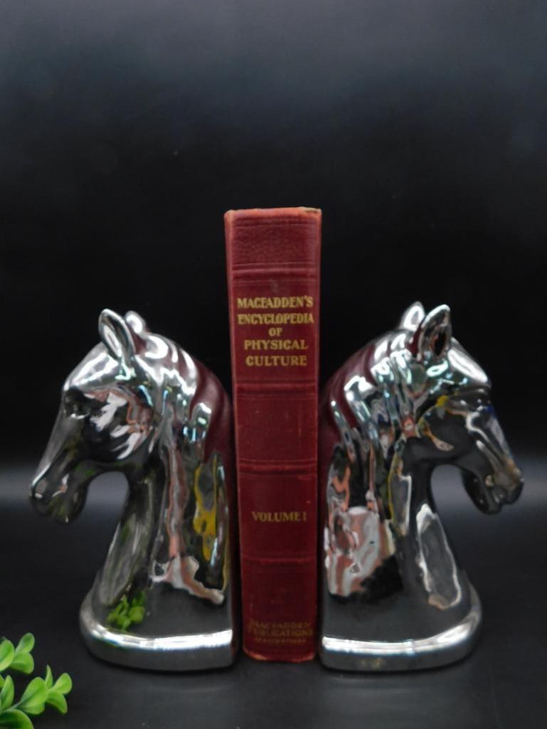 Pair of Chrome Horse Head Bookends: This is a set of two chrome-plated horse head bookends. Each features a highly reflective finish and detailed sculpting for a classic equestrian-themed design. These bookends are designed to hold book