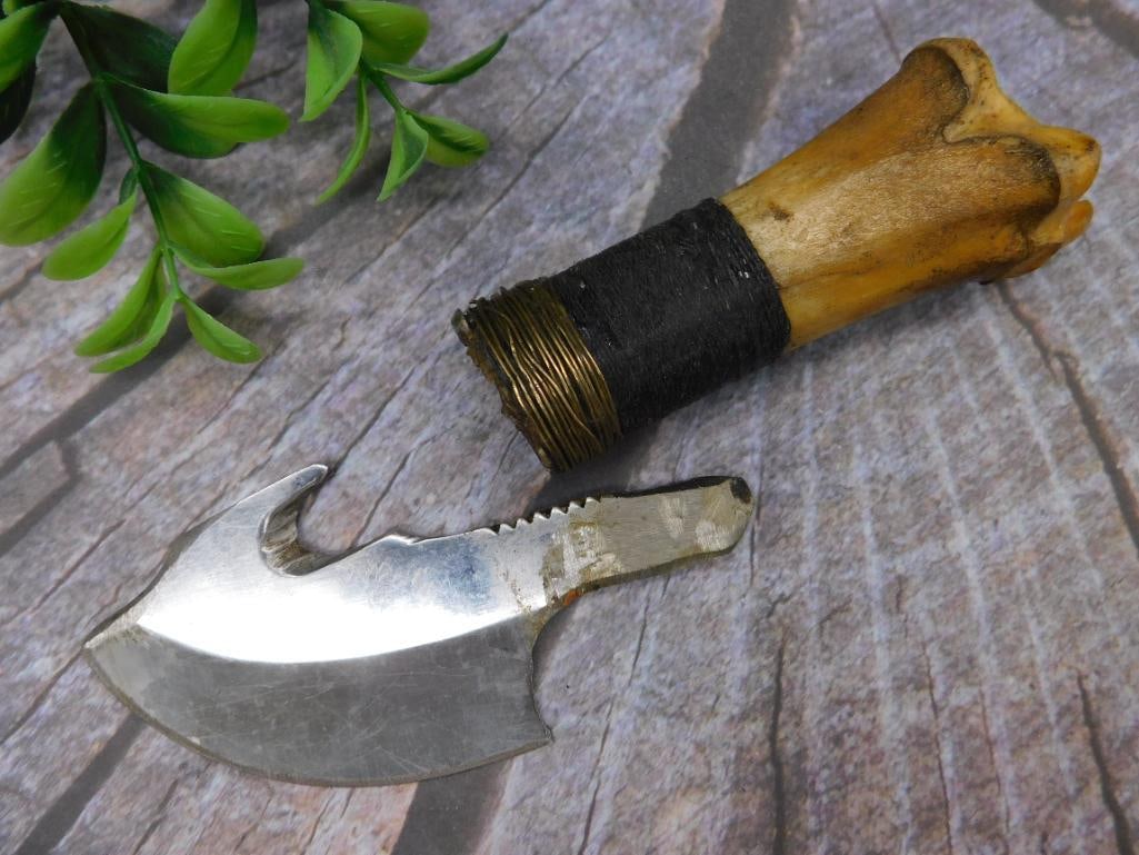 Small Bone-Handled Knife with Curved Blade: Uniquely designed knife featuring a bone handle and curved steel blade. The handle is securely wrapped with cord and wire for a firm grip. Includes a distinctive hooked and serrated edge blade, measur