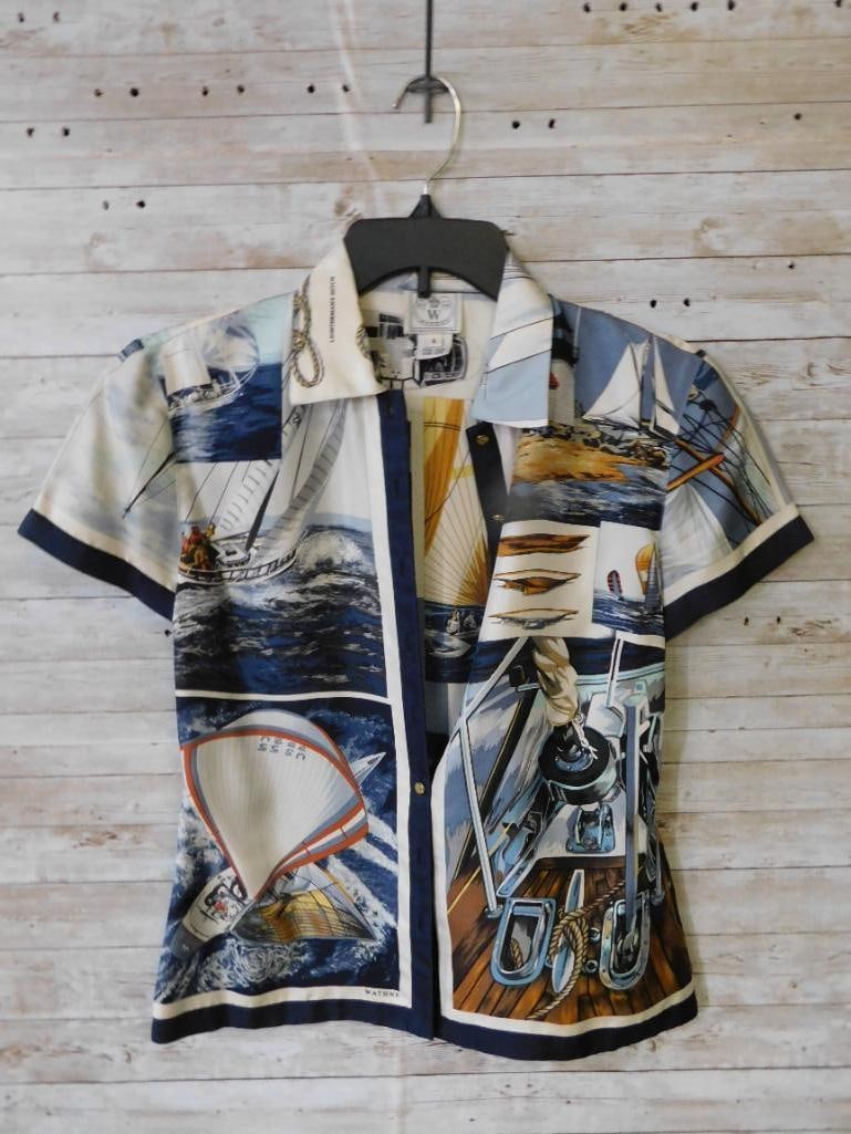 Short-Sleeve Nautical Themed Button-Up Shirt: Short-sleeve button-up shirt featuring a nautical print with sailboats and coastal imagery. Labeled as size 4 by 'Wathne' with a royal crest logo. Made in Hong Kong. Includes a contrast trim a