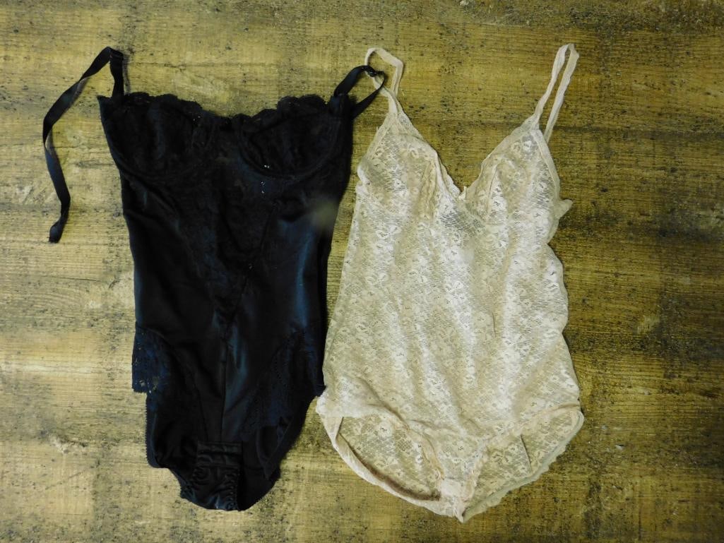 Two Women?s Lingerie Bodysuits in Lace and Satin: This lot includes two women's lingerie bodysuits: one in black satin with lace detailing and ribbon accents, and one in beige lace with adjustable straps. Both items are sleeveless and feature a f