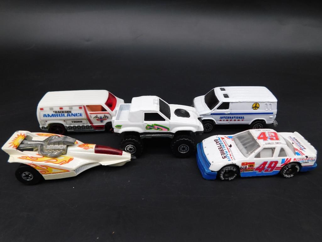 Set of Hot Wheels and Die-Cast Vehicles: This lot includes five die-cast toy vehicles, featuring cars, vans, and a drag racer. Some are marked with logos such as "Hot Wheels" and phrases like "Made in China" and "Made in Thailand." The cars