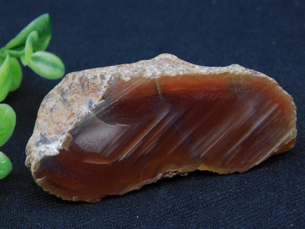 Reddish-Brown Polished Agate Mineral Specimen: A natural reddish-brown polished agate mineral specimen with unique banding visible on one surface. The specimen is unmounted and features a rough outer edge, contrasting with the polished face. The p