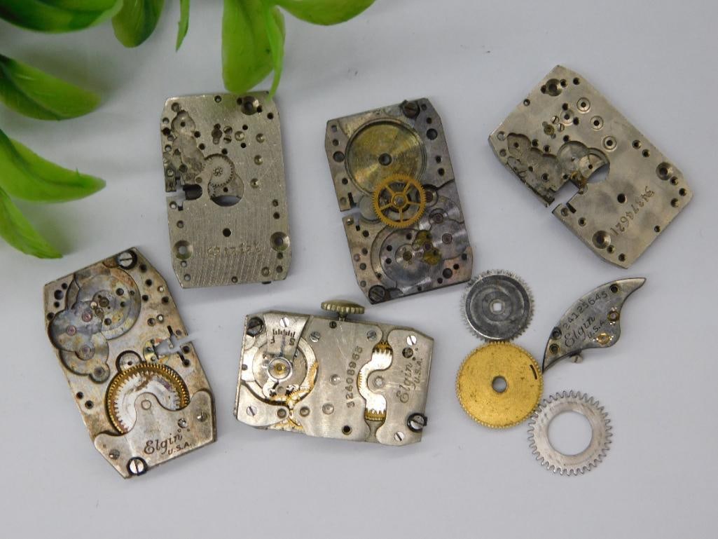 Vintage Pocket Watch Movements and Parts WATCHMAKER WATCHMAKING TOOLS: - Includes a collection of vintage pocket watch movements and parts. | - Brands visible include Elgin USA; some pieces unmarked or partially marked. | - Several gears, plates, winding mechanisms, and 