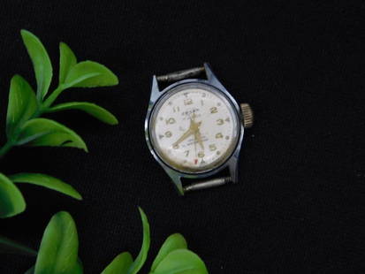 Vintage Mens Watch With Broken Main Spring WATCHMAKER WATCHMAKING TOOLS: - Vintage men's wristwatch. | - Brand: Appears marked as Timex on the dial. | - Face features white background with Arabic numerals in yellow. | - Labeled as shock-resistant on the dial. | - Back casi