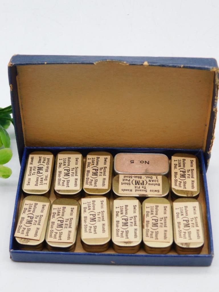 Vintage Box of Swiss Watch Hands 1 Dozen Blue Steel WATCHMAKER WATCHMAKING TOOLS: - Vintage box containing Swiss secret hands for watches. | - Each individual compartment is labeled as containing 1 dozen hands made of blue steel (Bulova PM style). | - Box shows moderate wear, consi