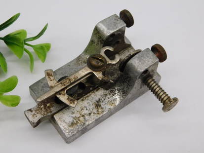 Vintage Small Metal Tool Clamp with Screw Adjustment Mechanism WATCHMAKER WATCHMAKING TOOL: - Functional vintage small metal clamp tool. | - Features a screw adjustment mechanism for secure fastening. | - Material: Metal, with visible signs of age and oxidation. | - Compact size, as shown