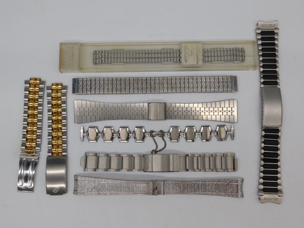 Vintage Stainless Steel And Gold-Tone Watch Bands WATCHMAKER WATCHMAKING TOOLS: Assortment of metal watch bands, some stainless steel and some with gold-tone accents. | Includes various styles and designs, including link bracelets, flexible bands, and a chain-link style. | Multip