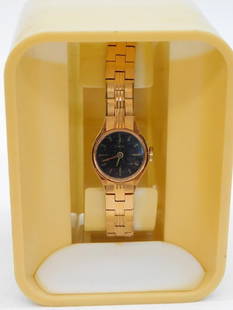 Vintage Timex Womens Gold-Tone Watch in Case WATCHMAKER WATCHMAKING TOOLS: Vintage women's Timex wristwatch with a gold-tone metal link bracelet. | Features a round black dial with hour markers and two hands. | Comes in a yellow plastic display case for storage or presentati
