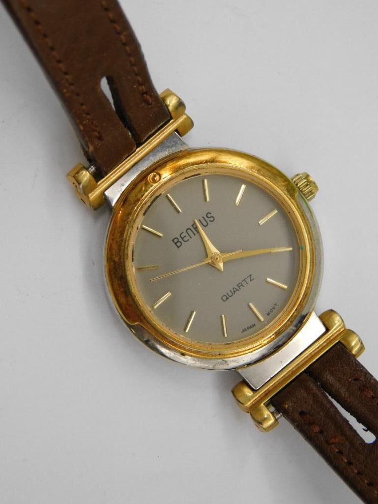 Womens Benrus Quartz Wristwatch with Leather Strap WATCHMAKER WATCHMAKING TOOLS: Benrus branded quartz wristwatch for women. | Features a gold-tone round case with metallic dial and baton hour markers. | Brown leather strap with standard buckle closure. | Analog display; hour, min