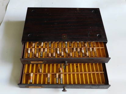 Wooden Case with Vials of Watch Parts by Swartchild & Co. WATCHMAKING WATCHMAKER TOOLS: Wooden case featuring two drawers with individual compartments. | - Drawers labeled "American Stems & Sleeves." | - Contains glass vials with cork stoppers, labeled with numbers and some containing sm