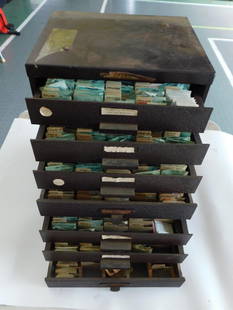 Vintage Watch Crystal Storage Cabinet with Contents WATCHMAKING WATCHMAKER TOOLS: Metal storage cabinet with multiple drawers designed for organizing watch crystals. | - Contains labeled compartments holding various vintage watch crystal packets organized by size, shape, and type.