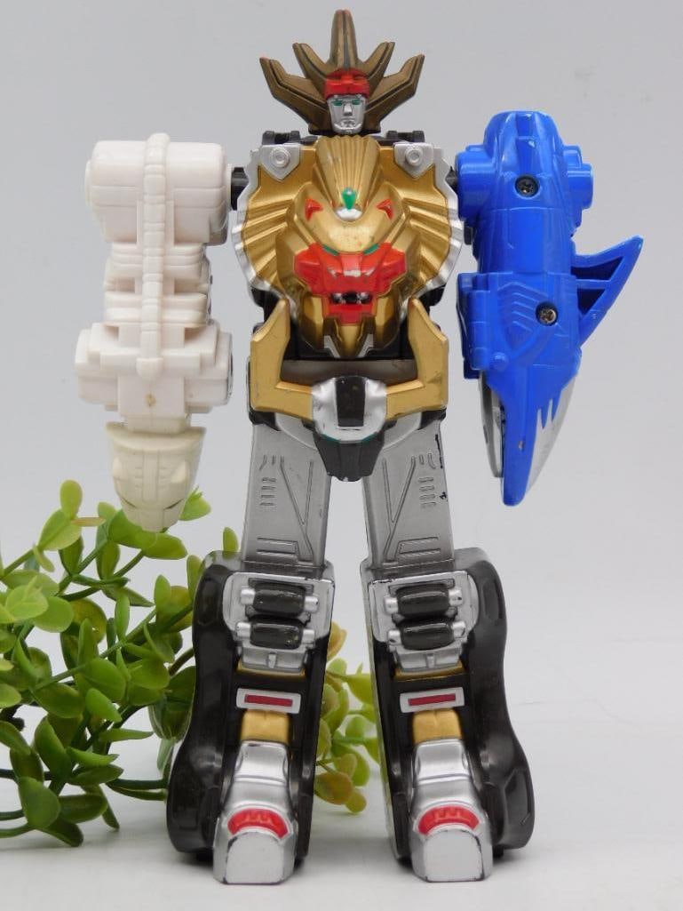 Power Rangers Action Figure with Lion Chest and Detachable Arms: - Action figure featuring a lion-themed chest design with metallic gold detailing. | - Includes detachable blue shark arm and white weaponized arm accessories. | - Constructed from durable plastic mat