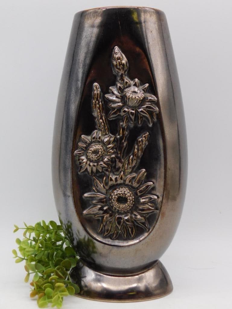 Vintage Ceramic Vase with Floral Relief Design: - Decorative ceramic vase featuring raised floral relief design on front. | - Outer surface has a glossy, metallic-like finish. | - Interior is glazed in a contrasting yellow color. | - Stands upright