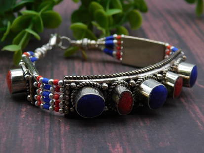 Lapis Lazuli and Red Coral Bracelet ROCK STONE LAPIDARY SPECIMEN: - Metal bracelet featuring red and blue stones. | - Embellished with small beads in red, white, and blue accents on wristbands. | - Fastens with a hook clasp for secure closure. | - Measures approxima
