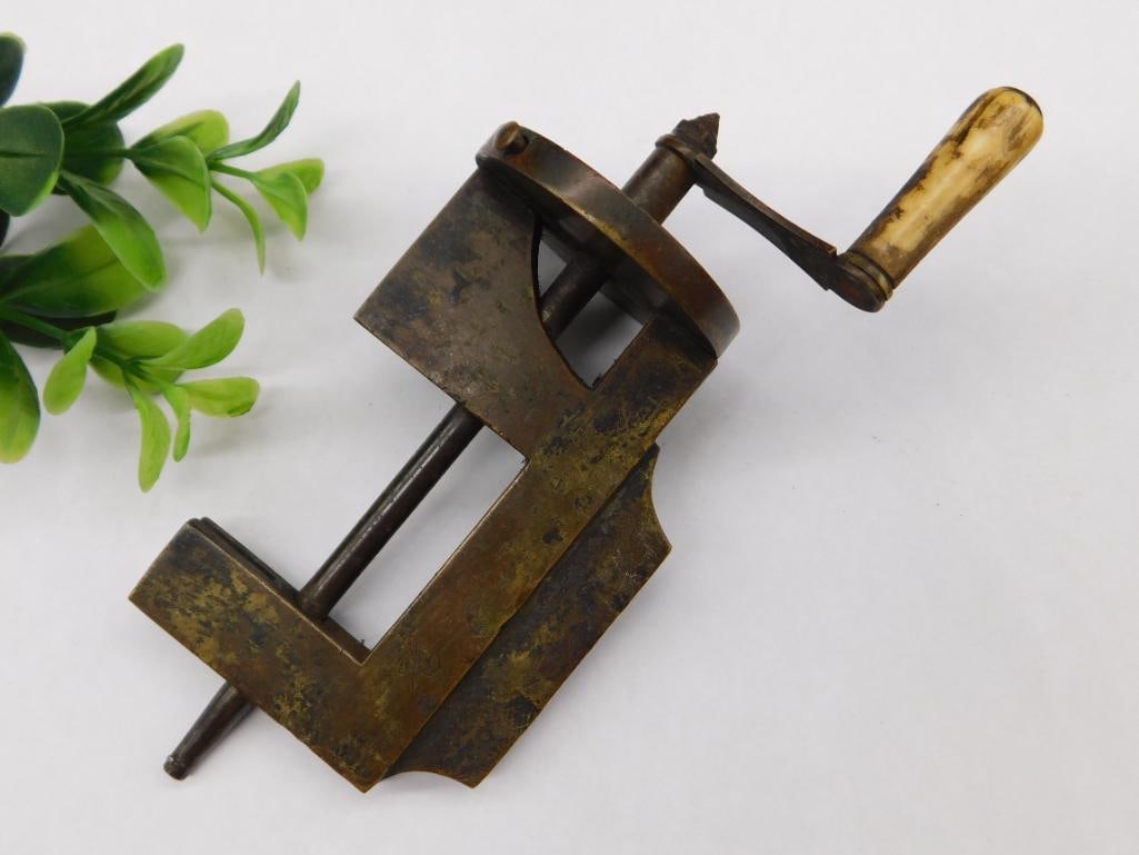 Vintage Brass and Bone-Handled Hand Crank Clamp WATCHMAKER WATCHMAKING TOOLS: - Vintage hand-operated clamp made of brass with a natural bone handle. | - Features a screw-style tightening mechanism operated by a hand crank. | - Exhibits a patina consistent with age and use, add