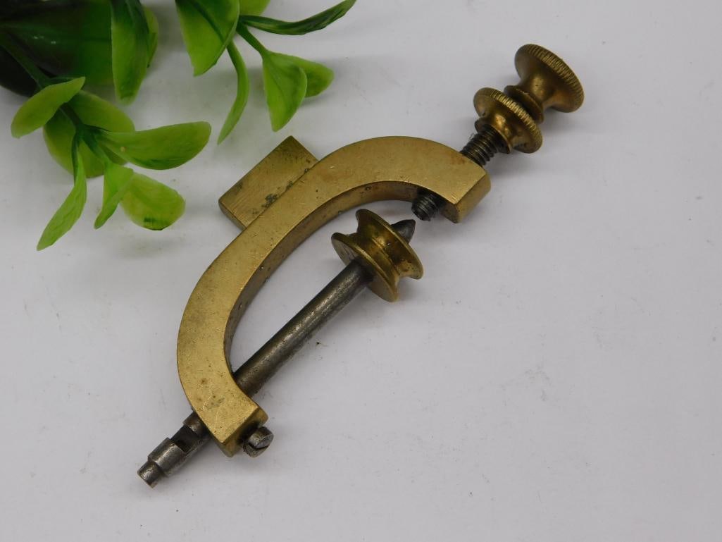Antique Brass and Steel Clamp with Screw Adjustment: Antique brass and steel clamp featuring a screw adjustment mechanism. | Compact size, ideal for precise and small-scale applications. | Sturdy brass frame paired with a steel screw and adjustable fitt
