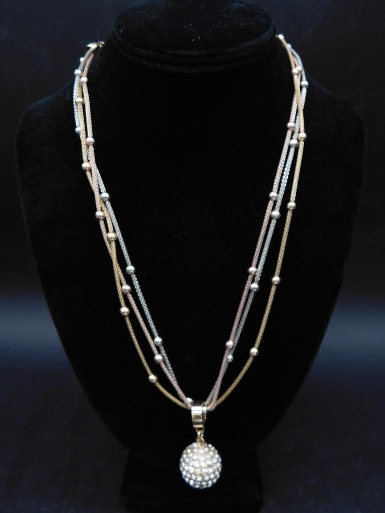 Gold-Toned Multi-Strand Necklace With Rhinestone Pendant: - Multi-strand gold-toned necklace featuring interwoven chains with decorative beads. | - Highlighted by a spherical pendant encrusted with sparkling rhinestones. | - Lobster clasp closure for secure