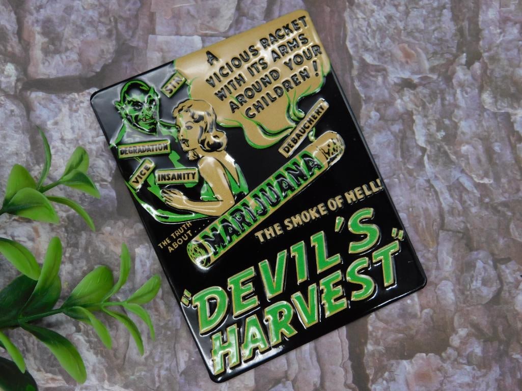 Devils Harvest Metal Magnet Decorative Plate: A metal sign plate featuring the ?Devil?s Harvest? design with bold text and artwork. The imagery includes various slogans, characters, and a retro-style theme. It appears to be constructed of durable
