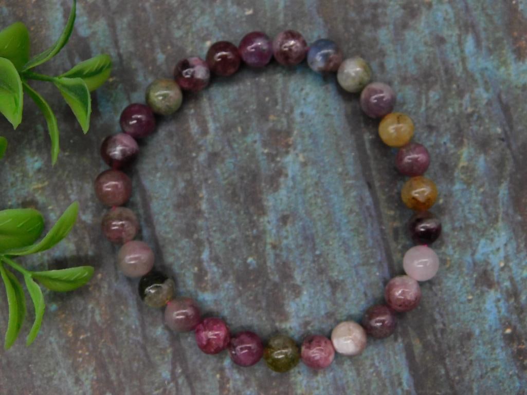 Multicolored Beaded Stretch Bracelet: This is a multicolored beaded stretch bracelet featuring polished round beads in varying tones. The bracelet is designed with elastic for an adjustable fit, making it versatile for different wrist siz