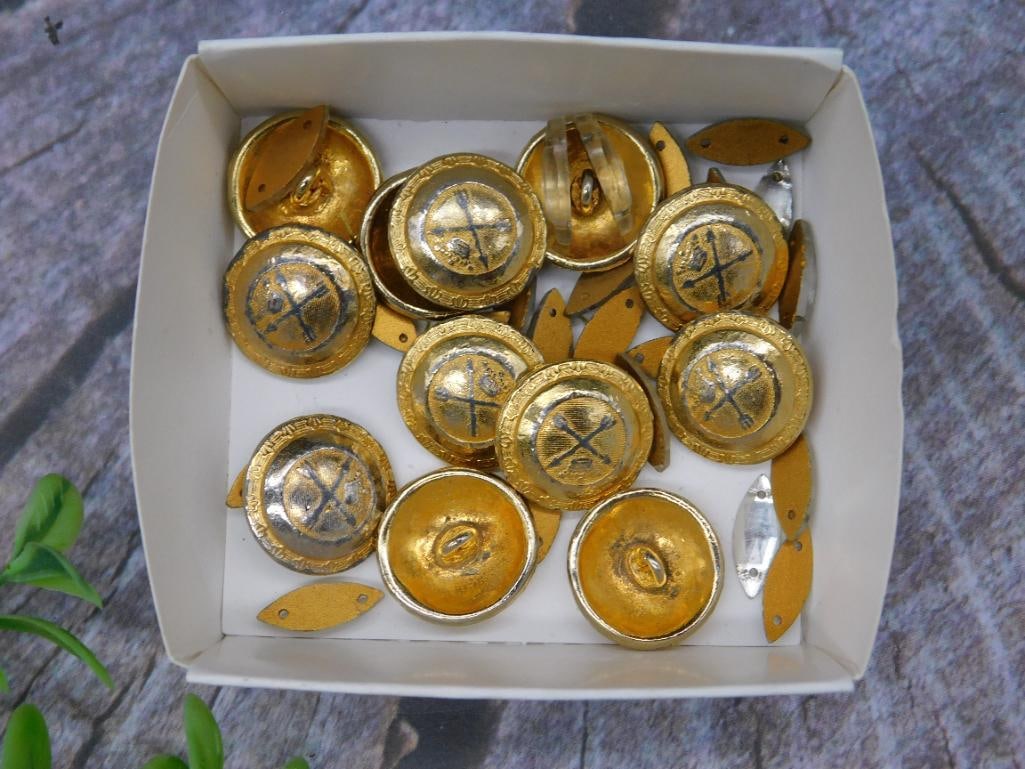Box of Gold-Toned Decorative Buttons: A box containing multiple gold-toned decorative buttons, circular with intricate detailing. Includes various matching designs, as seen in the images. Comes in a white box for storage or display. Dimen