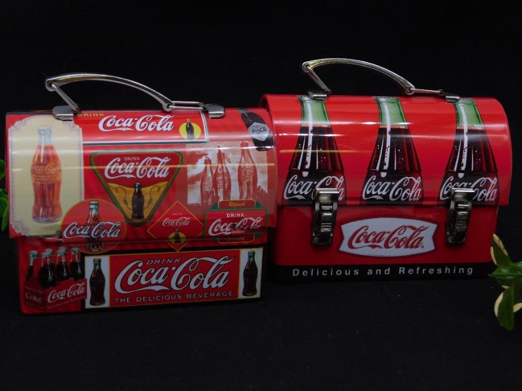 Vintage Coca-Cola-Themed Miniature Lunchboxes: - Set of two miniature lunchboxes featuring Coca-Cola branding. | - Made from metal with vibrant, multicolor Coca-Cola advertisements and design motifs. | - Each box is equipped with a sturdy metal ha