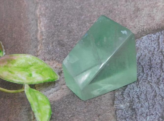 Green Fluorite Crystal ROCK STONE LAPIDARY SPECIMEN: Green fluorite crystal with a faceted shape. The stone is displayed alongside a coin for size reference and includes an auction lot tag, identified as Lot 708484 from the Christie Hatman 2025 Rock Auc