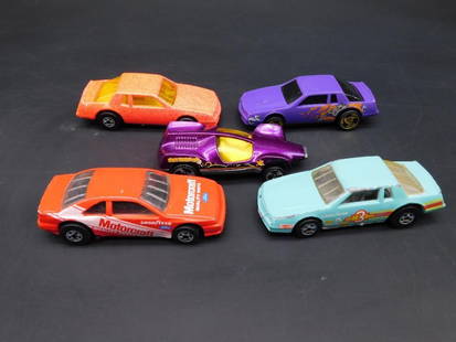 Lot of Five Mattel Hot Wheels Cars from 1980s: Collection of five vintage Hot Wheels cars manufactured by Mattel in the 1980s. Includes varying models and colors, marked on their bases with production years and origin (Malaysia or Thailand). Each