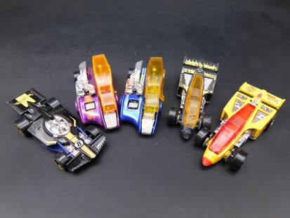 Lot of 5 Hot Wheels Formula 1 and Drag-Style Cars: Collection of five Hot Wheels vehicles, including Formula 1 and drag-style designs in various colors. Cars are marked with 'Mattel Inc.' and 'Hot Wheels' logos, with manufacturing stamps for Malaysia