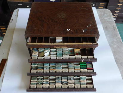 Bulova Watch Parts Cabinet With Drawers WATCHMAKING WATCHMAKER TOOLS: - Vintage wooden cabinet branded 'Bulova Genuine Standardized Parts.' | - Features multiple stacked drawers, some labeled with part types (e.g., mainspring, pallet arbor). | - Contains assorted vintag