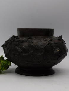 Japanese Meiji Period Bronze Vase with Bird and Floral Motif: Antique Japanese bronze vase with a raised bird and floral design. | Likely from the Meiji period, showcasing intricate craftsmanship. | Features a broad, round body tapering to a slightly flared rim.