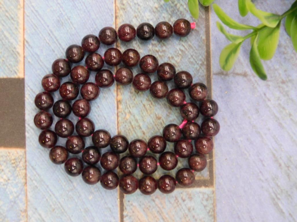 Strand of Garnet Beads for Jewelry Making Rock Stone Lapidary Specimen: Strand of polished garnet beads. | Each bead is spherical in shape. | Total weight of the beads is approximately 40 grams. | Measurements and sizing clearly indicated with included ruler for scale. | 