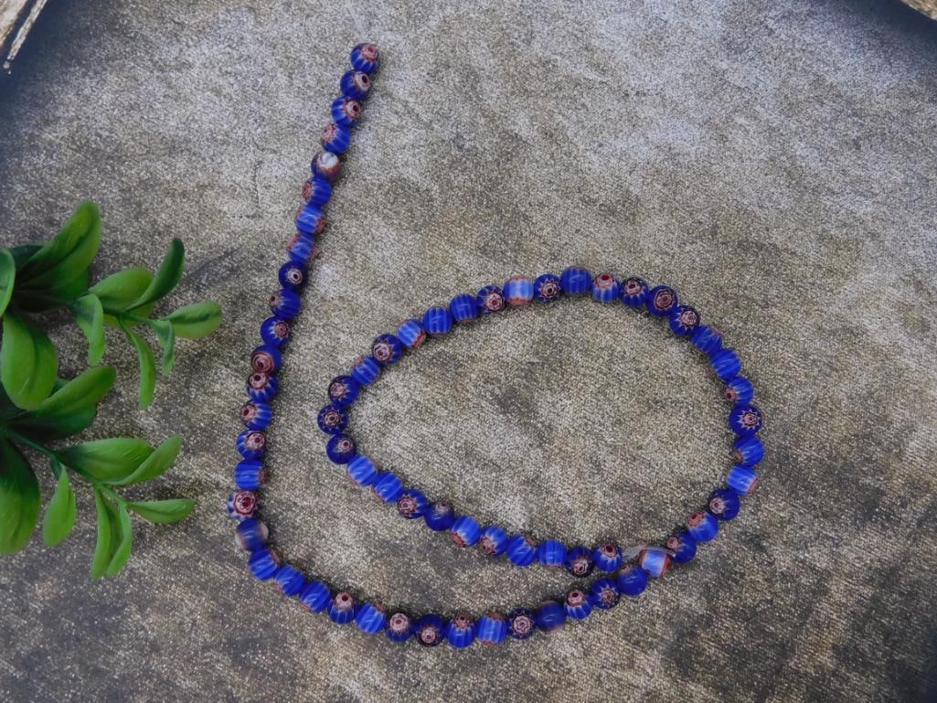African Trade Beads Rock Stone Lapidary Specimen: - Elegant beaded necklace featuring alternating blue and pink beads with diverse patterns. | - Beads are strung in a single continuous strand without visible clasp. | - Length is approximately 24 inch