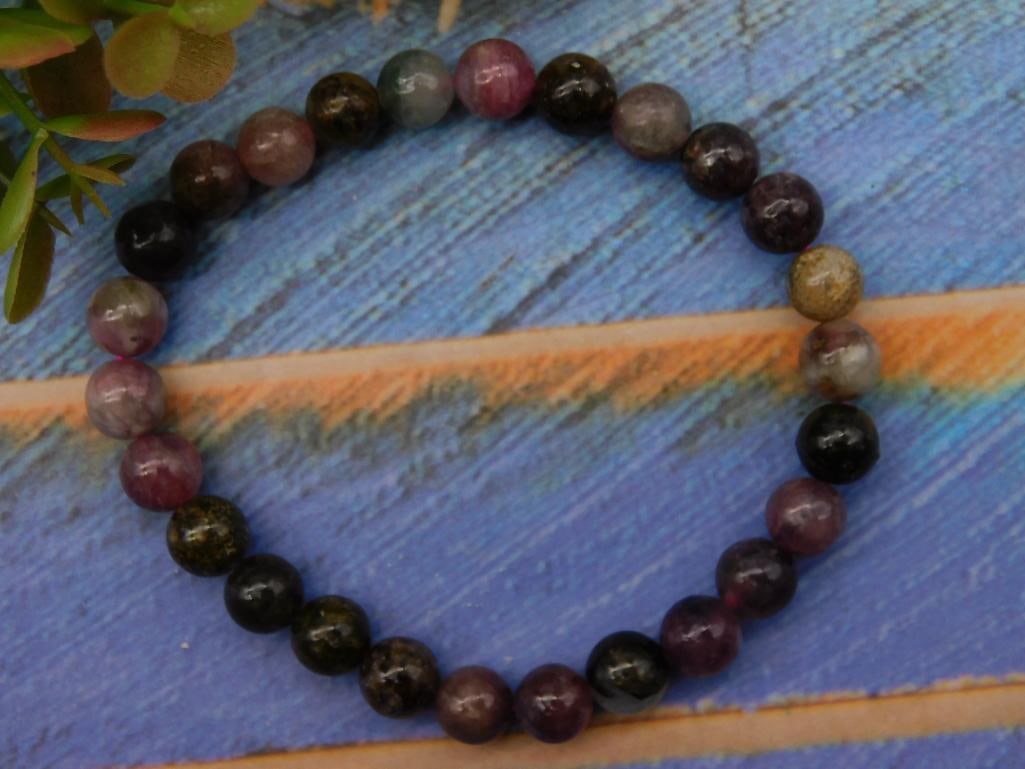 Multicolored Beaded Stone Bracelet ROCK STONE LAPIDARY SPECIMEN: Multicolored round stone beads strung together to form a bracelet. | Features shades of purple, black, and gray, creating a vibrant, natural gemstone appearance. | Elastic cord construction for flexib
