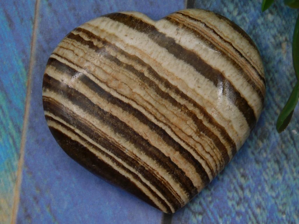 Banded Jasper Heart ROCK STONE LAPIDARY SPECIMEN: Polished, heart-shaped stone featuring a natural striped pattern. | Smooth finish showcasing varying shades of brown and cream. | Includes a lot tag referencing Lot No. 710394 for the 2025 Rock Auctio