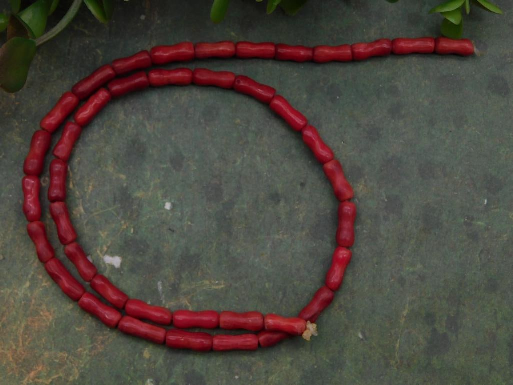 Red Coral Beads ROCK STONE LAPIDARY SPECIMEN: Double-stranded necklace featuring red cylindrical beads. | Beads are consistent in size and shape, creating a uniform look. | The strand is presented unfastened, laid out in the image. | Likely suita