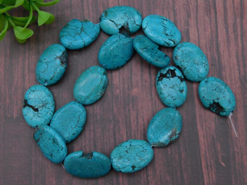 Strand of Oval Turquoise-Style Beads ROCK STONE LAPIDARY SPECIMEN: Strand of turquoise-style beads in an oval shape. | Vibrant blue color with black veining throughout. | Contains approximately 15 beads strung together. | Beads are uniformly shaped and polished. | To