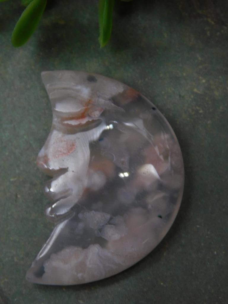 Carved Moon Face Agate Figure Rock Stone Lapidary Specimen: Hand-carved moon face figure made from agate gemstone. | Features a translucent appearance with natural inclusions and patterns. | Approximate weight of 10 grams, as indicated on the label. | Dimensio