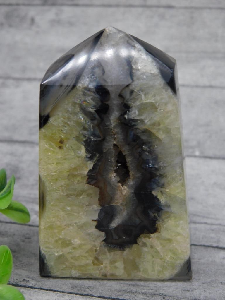 Polished Quartz Crystal with Geode Center Display Piece: Polished quartz crystal featuring a naturally formed geode center. Measures approximately 84 grams in weight. The piece showcases a complex texture with visible layers and crystalline structure. Ideal