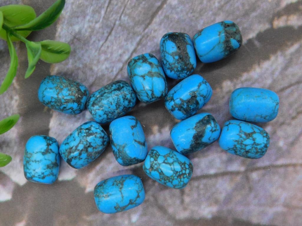 Lot of Blue Turquoise Beads for Jewelry Making: Lot of 14 blue simulated turquoise beads with black veining patterns. Beads are barrel-shaped and polished for a smooth finish. Weighing approximately 34 grams as noted on the lot card. Ideal for craf