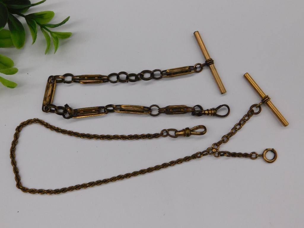 Antique Brass Double Albert Watch Chain with T-Bar: - Antique brass double Albert watch chain, featuring two decorative T-bars for securing a pocket watch or similar accessory. | - Design includes elongated rectangular links with textured and polished