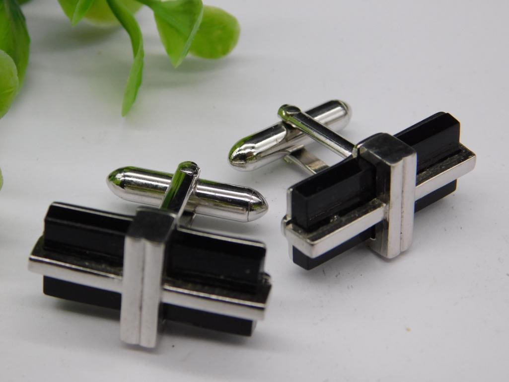 Sterling Silver and Black Onyx Cufflinks with Markings: - A pair of sterling silver cufflinks featuring black onyx accents. | - Marked with '925' indicative of sterling silver purity. | - Barrel-style design with a polished finish. | - Secure toggle clasp 