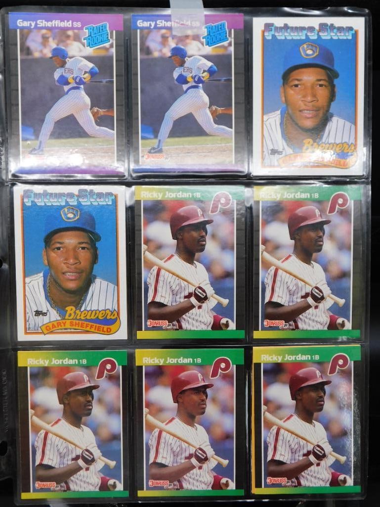 Baseball Cards in Plastic Pages: - Includes multiple baseball cards with images, names, and team affiliations printed on each. | - Cards are organized into plastic pages, allowing for easy viewing and storage. | - Visible player name