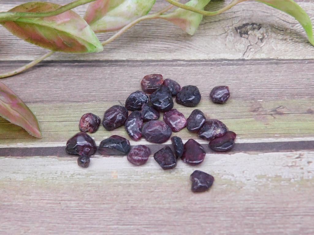Natural Rough Garnet Gemstone Lot: Lot of rough garnet gemstones in varying sizes and shapes. Natural, untreated stones with deep crimson hues. The total weight is not specified. Perfect for gem enthusiasts, collectors, or crafting pro