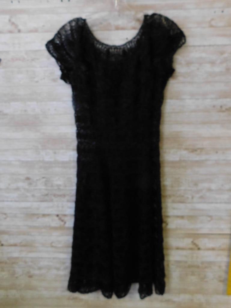 Black Crochet Pattern Dress with Short Sleeves: Black dress featuring an intricate crochet pattern. Includes short sleeves, a round neckline, and a scalloped hem design. Lightweight and unlined, providing a delicate and airy look. A measuring stick